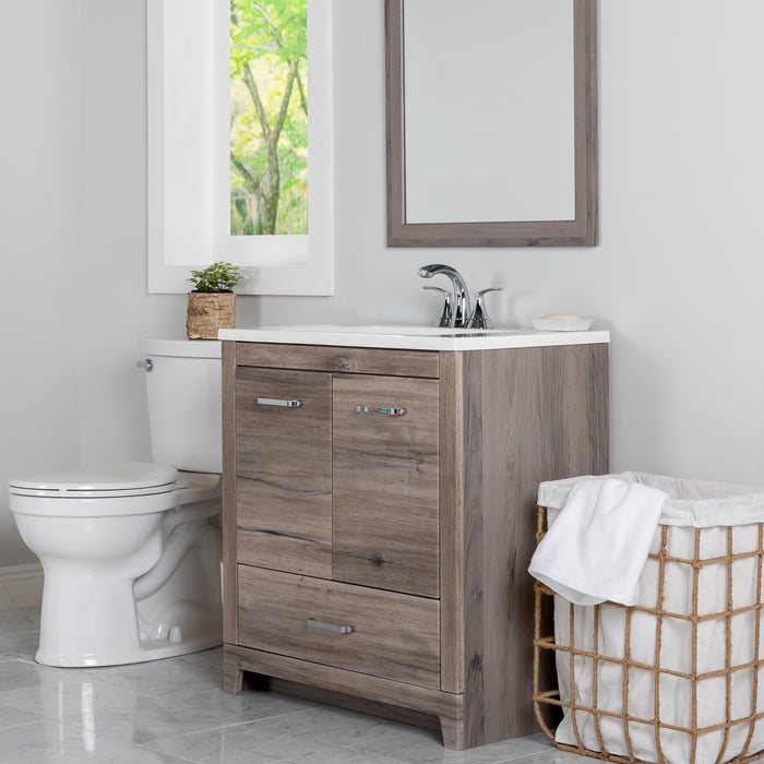 30.25 in Breena half-bath vanity with woodgrain laminate finish, 2-door cabinet, base drawer, chrome hardware installed in bathroom with faucet and mirror