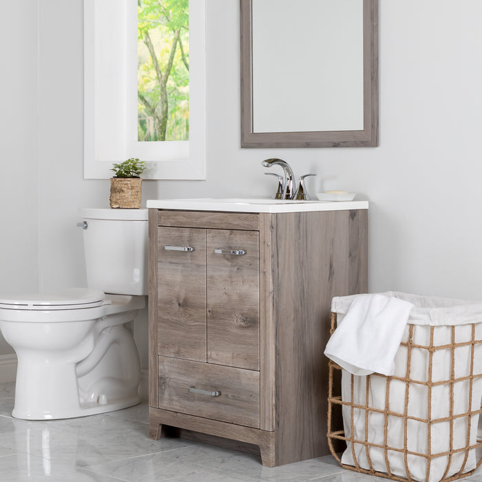 24.25 in Breena bathroom vanity with woodgrain laminate finish, 2-door cabinet, base drawer, chrome hardware installed in bathroom with faucet and mirror