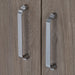 Close up of polished chrome cabinet door handles on medium woodgrain doors of Callen vanity by Spring Mill Cabinets, Two door medium woodgrain box-style bathroom cabinet