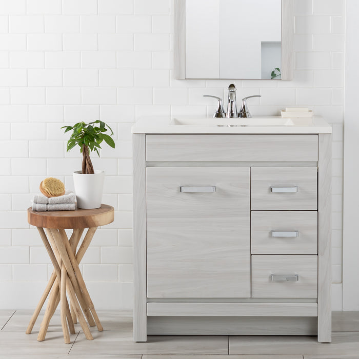 Devere light woodgrain bathroom vanity with 3 drawers, cabinet, sink top installed in bathroom with faucet and mirror