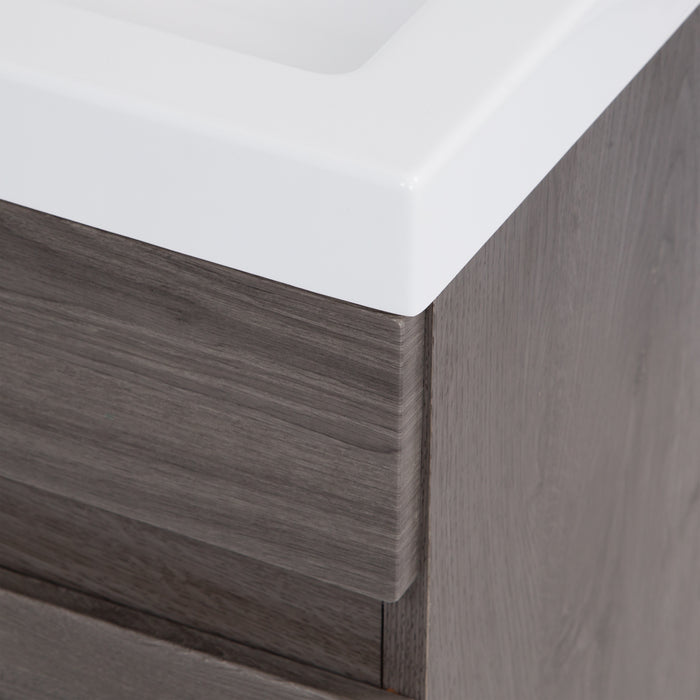 Closeup of corner of white cultured marble sink top on Muriel 24.5" W woodgrain cabinet-style bathroom vanity 