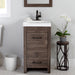 Nixie 18.5" wide woodgrain 1-door, 1-drawer bathroom vanity installed in bathroom with plant and mirror