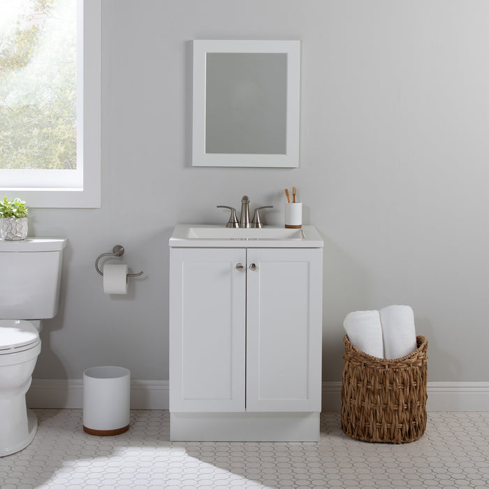 Yereli 24.25" W white Shaker-style vanity with 2 flat-panel doors, white sink top installed in bathroom with toilet and mirror